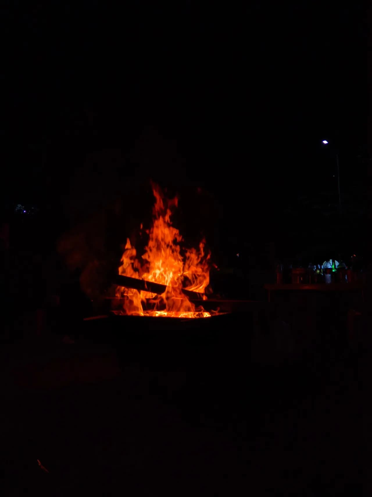 A bonfire burning on the grounds at night