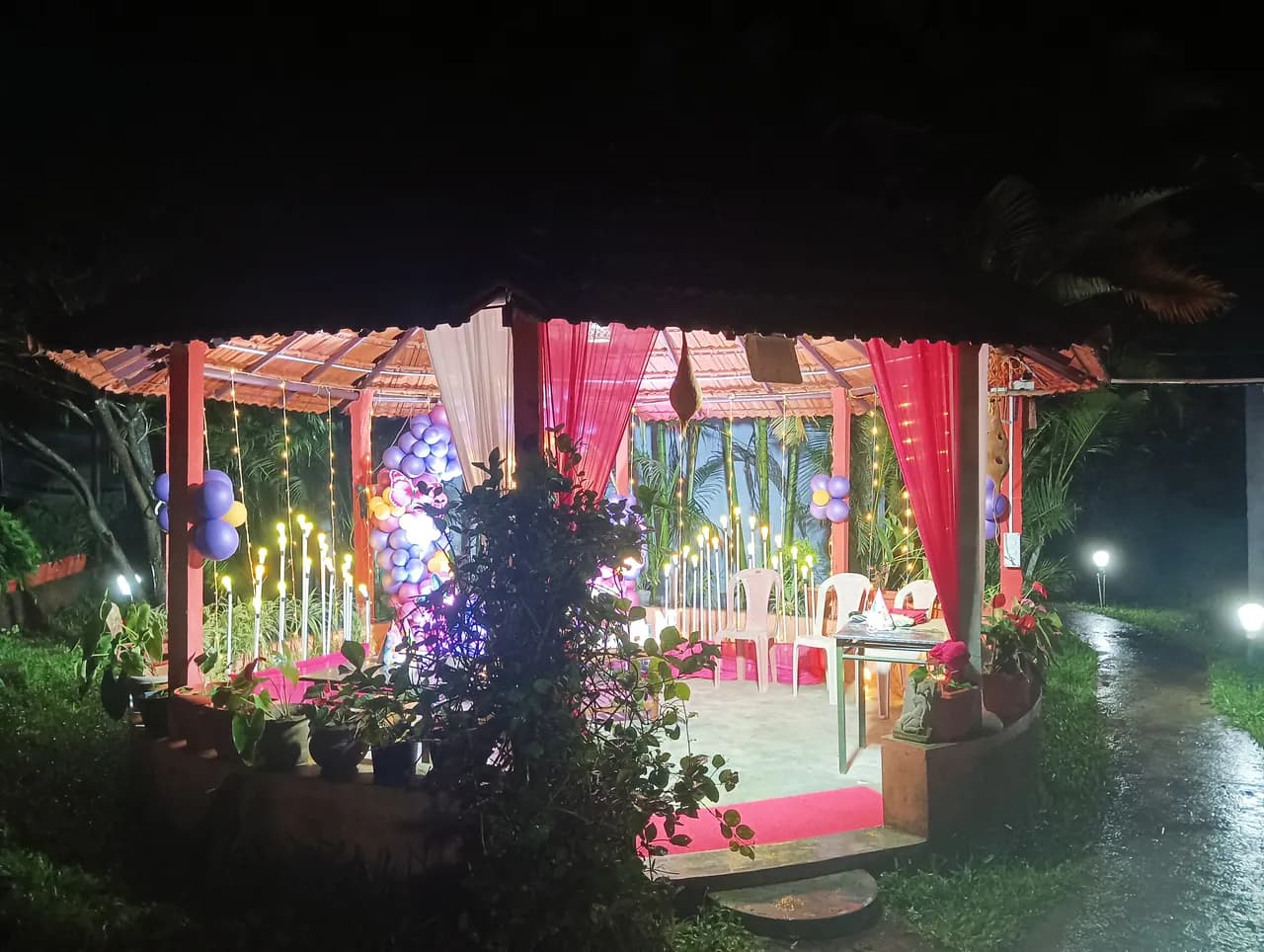 A decorated open pavilion strung with lights, set for a function