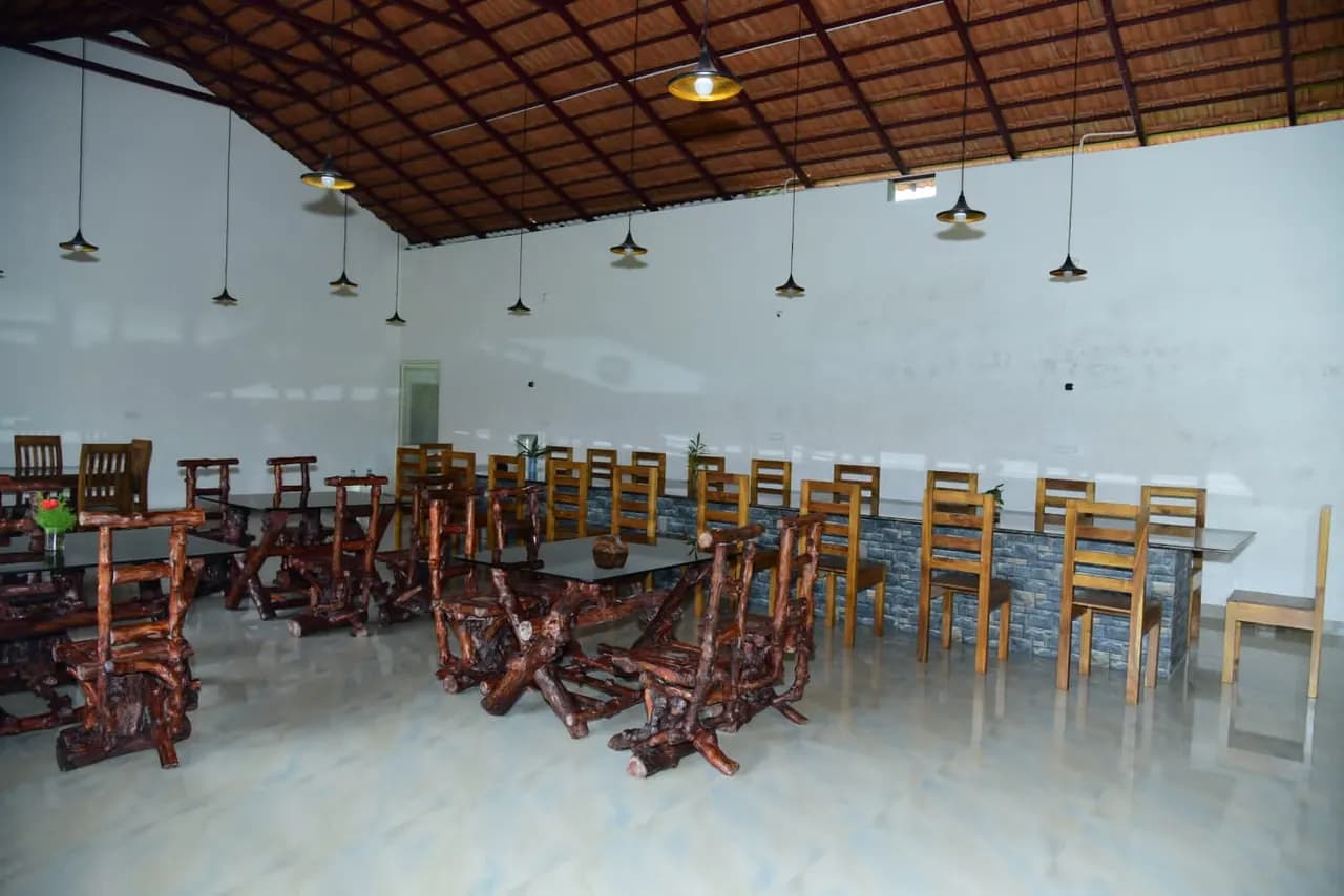 The dining hall in daylight, carved wooden tables under a tiled roof