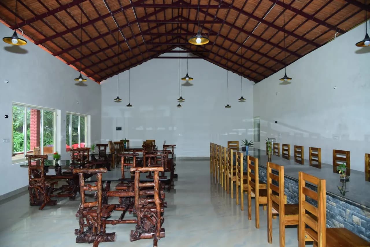 Rows of wooden tables and chairs beneath the pitched roof trusses