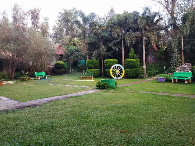 Open lawn with the painted cartwheel and garden benches