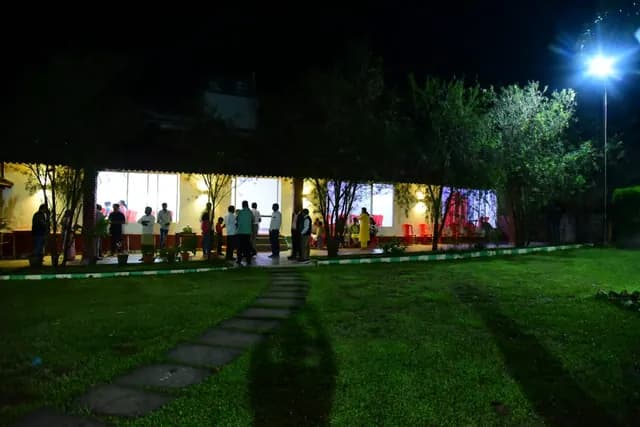 The cottage block lit up across the lawn after dark
