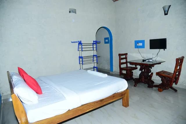 Guest room with a blue accent wall, twin beds and a writing table